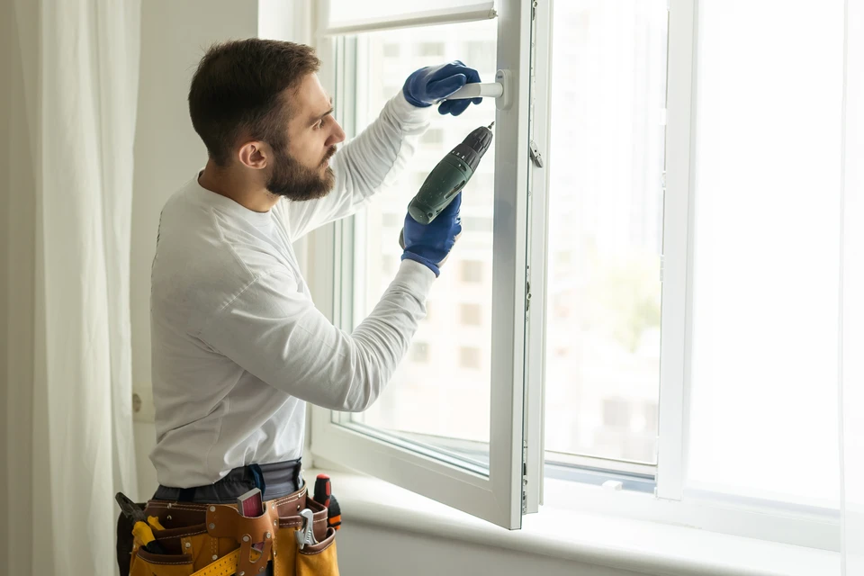 Maison contemporaine à deux niveaux avec façade blanche et grise, grandes baies vitrées coulissantes au rez-de-chaussée, fenêtres étroites à l'étage