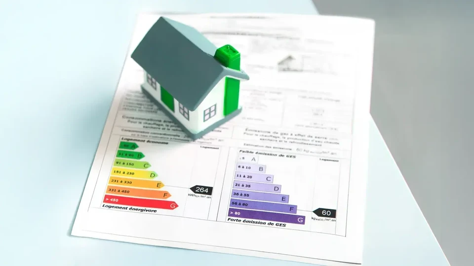 Homme et femme en casques de sécurité rouges examinent des plans architecturaux dans un bâtiment en construction